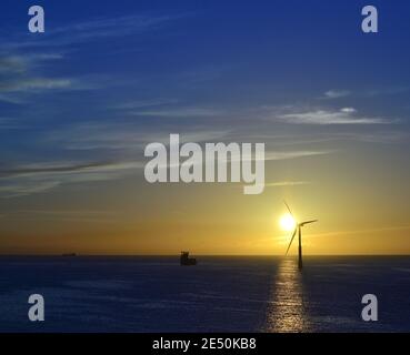 Beau lever de soleil avec un ciel splendide et une éolienne dans la mer, côte de Gran Canaria, Espagne Banque D'Images