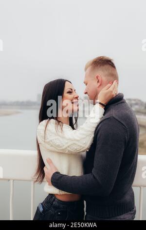 La jeune femme hante doucement son homme contre le fond d'un paysage de rivière brumeux. Photo de haute qualité Banque D'Images