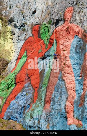 Workman accroché à des cordes, la restauration de peinture de la murale de la Préhistoria, le mur préhistorique, par Leovigildo Gonzalez, vallée de Vinales, Pinar del Rio, C Banque D'Images