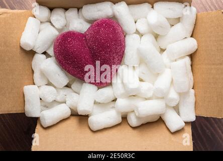 cœur rouge dans une boîte en carton avec garniture en mousse de polystyrène pour le concept de coeur fragile Banque D'Images