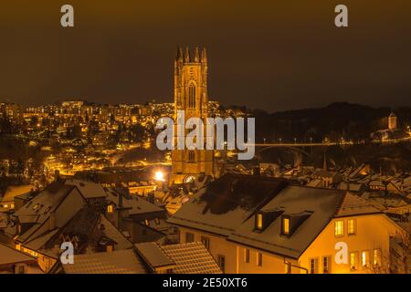 Plan de nuit de Fribourg (Suisse) sous la neige, avec la cathédrale Saint-Nicolas au milieu Banque D'Images