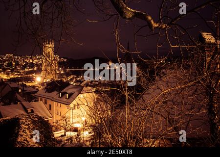 Plan de nuit de Fribourg (Suisse) sous la neige, avec la cathédrale Saint-Nicolas au milieu Banque D'Images
