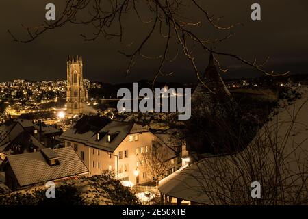 Plan de nuit de Fribourg (Suisse) sous la neige, avec la cathédrale Saint-Nicolas au milieu Banque D'Images