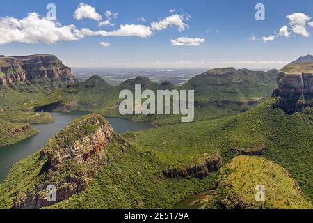 Prise de vue en grand angle du Blyde River Canyon couvert par végétation verte luxuriante sous un ciel bleu avec des nuages Banque D'Images