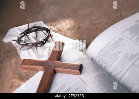 Couronne d'épines et croix en bois sur fond de bible ouvert avec espace de copie pour l'inscription. Concept de Pâques chrétienne. Banque D'Images
