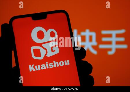 Logo de l'application Kuaishou visible sur l'écran du smartphone et arrière-plan flou avec des lettres chinoises traduites en « application Kuaishou ». Flux vidéo chinois populaire Banque D'Images