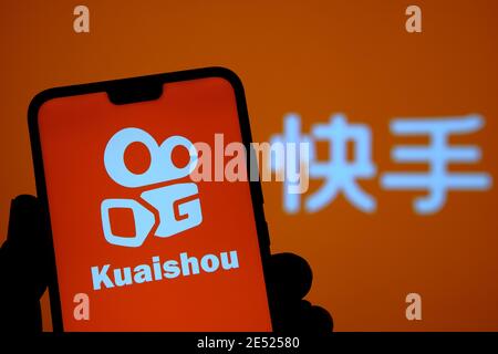 Logo de l'application Kuaishou visible sur l'écran du smartphone et arrière-plan flou avec des lettres chinoises traduites en « application Kuaishou ». Flux vidéo chinois populaire Banque D'Images