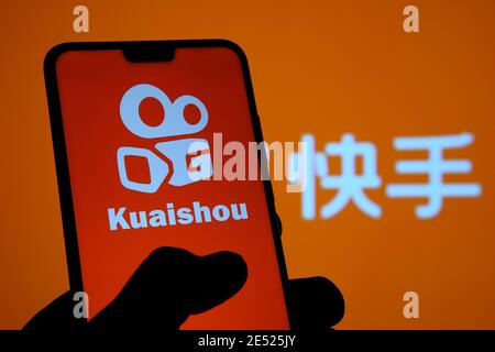 Logo de l'application Kuaishou visible sur l'écran du smartphone et arrière-plan flou avec des lettres chinoises traduites en « application Kuaishou ». Flux vidéo chinois populaire Banque D'Images