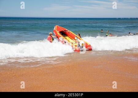 Sauvetage de surf volontaire sauveteurs lancer gonflable rouge zodiac surf sauvetage Bateau à Bilgola Beach à Sydney, Nouvelle-Galles du Sud, Australie Banque D'Images