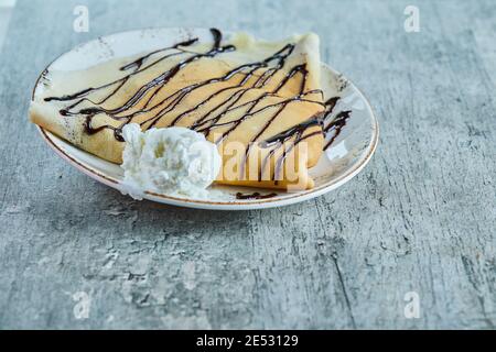 Crêpes à la crème glacée à la vanille, chocolat sur la plaque blanche sur fond de marbre Banque D'Images