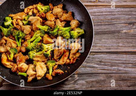 Remuez avec le poulet et le brocoli sur le wok. Cuisine chinoise. Copier l'espace. Banque D'Images