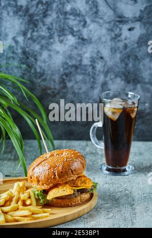 Grand hamburger avec pommes de terre frites dans l'assiette en bois l'arrière-plan en marbre Banque D'Images