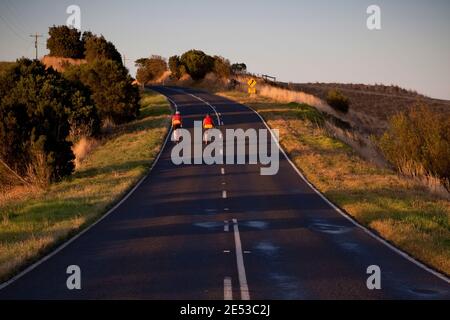 Cyclistes au crépuscule dans la chaîne des Strzelecki Ranges, Victoria, Australie. Banque D'Images
