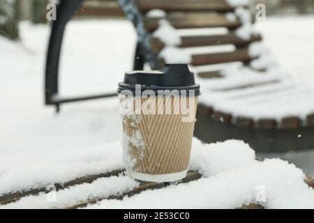 Tasse en papier vierge sur banc à l'extérieur en hiver Banque D'Images
