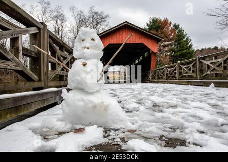 St. Clairsville, Ohio/USA-le 17 novembre 2018 : bonhomme de neige devant le pont couvert Shaeffer Campbell dans le comté de Belost lors d'une journée hivernale. Banque D'Images