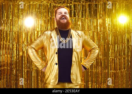 Drôle heureux barbu homme dans une tenue extravagante debout mains sur hanches et rire Banque D'Images