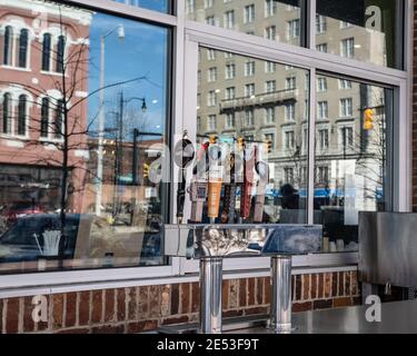 Montgomery, Alabama/USA-20 janvier 2018: Robinets à bière à l'extérieur du Mellow Mushroom avec des bâtiments historiques de Commerce Street reflétés dans la fenêtre Banque D'Images