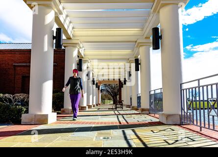 Montgomery, Alabama, États-Unis - 28 janvier 2017 : une femme traverse la véranda ouverte du Montgomery Museum of Fine Arts lors d'une journée d'hiver très vive. Banque D'Images