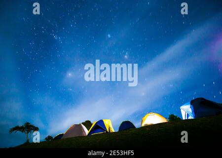 Tentes de camp illuminées sous le ciel étoilé, camping sur la montagne en hiver. Mise au point douce. Banque D'Images