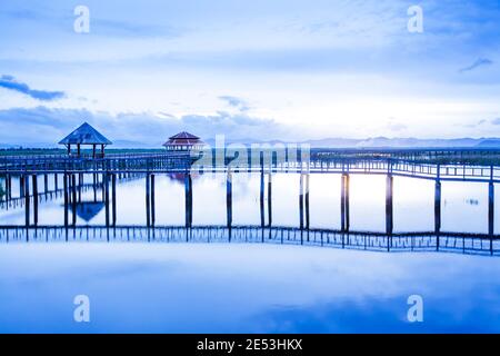 Un lac tropical tranquille et une promenade en bois le matin de l'été, une promenade pittoresque en bois avec belvédère se reflète sur le lac. Sam Roi Yod, Thaïlande. Banque D'Images