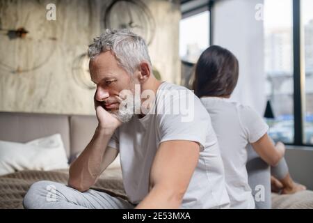 Homme malheureux assis à l'arrière de la femme Banque D'Images