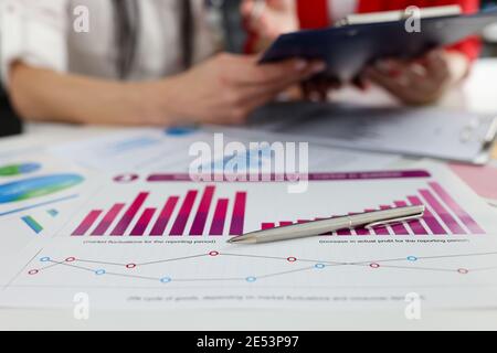 Stylo à bille reposant sur des documents avec des graphiques et des diagrammes en gros plan Banque D'Images