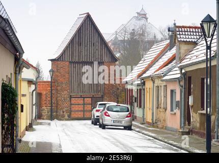 18 janvier 2021, Brandebourg, Kyritz: Vue de Mauerstraße de la section d'environ 200 mètres de long de la muraille historique de la ville avec porte de la ville entre Holzhausener Straße et Graf-von-der-Schulenburg-Straße. Le mur avait été construit aux XIIIe et XIVe siècles et avait trois portes de ville. Au XVIIIe siècle, les fortifications et les parties du mur ont commencé à être démolies. La partie est a ensuite été rénovée de 2003 à 2006, la partie près de Holzhausener Straße en 2008 et 2009. En arrière-plan sur la droite, vous pouvez voir le toit couvert de neige de l'école primaire Goethe. Photo: Soeren Stac Banque D'Images