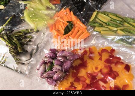 sacs scellés sous vide pour cuire sous vide avec des poivrons, des courgettes et des échalotes, des carottes fraîches et des asperges Banque D'Images