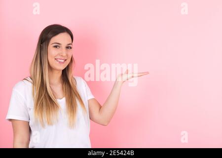 une jeune femme montre de l'espace sur le côté. Image pour le marketing et la publicité Banque D'Images