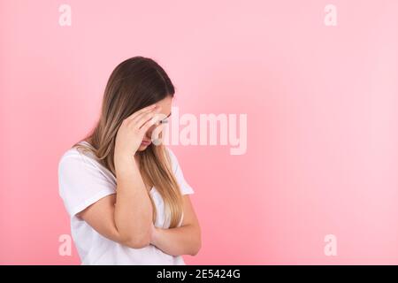 une jeune femme montre de la tristesse en se cachant derrière sa main Banque D'Images