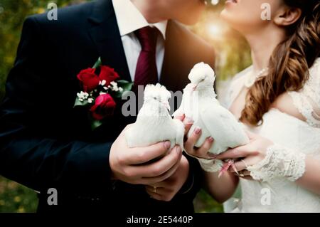 Les jeunes mariés ont une paire de pigeons blancs. Mariage. Banque D'Images