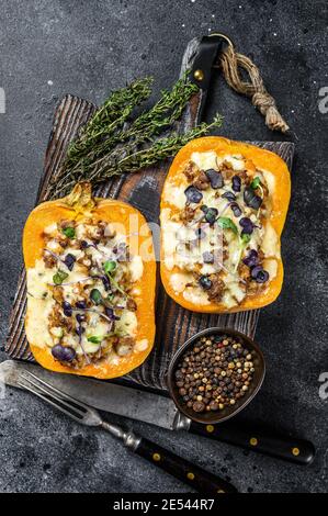 Citrouille farcie de viande de bœuf hachée, de légumes et d'herbes fond noir. Vue de dessus Banque D'Images