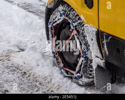 Voiture avec chaînes à neige sur les pneus d'hiver Banque D'Images