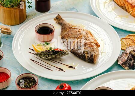 Poisson dorada grillé gastronomique sur la table servie Banque D'Images