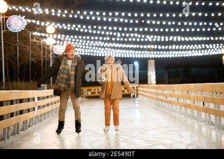 Joyeux couple d'âge mûr, faites des activités sur la patinoire pendant Noël vacances Banque D'Images