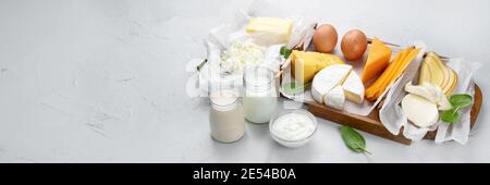 Différents produits laitiers frais sur fond gris. Banque D'Images
