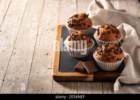 Des muffins au chocolat juste sortis du four sur une table en bois Banque D'Images