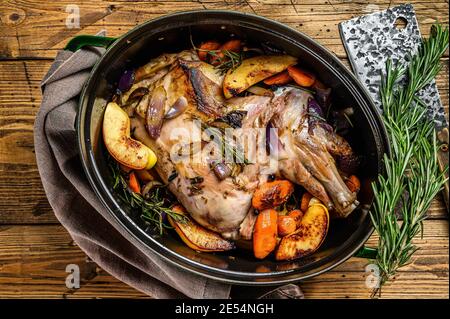 Dans un plat de cuisson, on a fait cuire toute l'épaule d'agneau. Arrière-plan en bois. Vue de dessus Banque D'Images