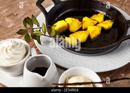Dessert de brochette d'ananas et de glace aromatisée à la vanille et chocolat Banque D'Images