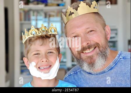Le père et le fils ont mis la couronne sur leur tête et Amuse-toi bien. Le père a une barbe. Son a fait une barbe avec de la mousse à raser Banque D'Images