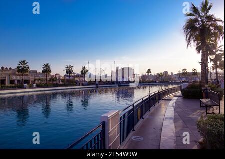 Belle vue sur les pavillons, et Canal avec bateaux de plaisance dans le centre de divertissement du parc capturé au coucher du soleil à Global Village, Dubaï Banque D'Images