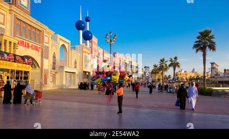 Touristes , acheteurs et vendeurs capturés au parc de divertissement dans la soirée au Village global , Dubaï, Émirats Arabes Unis. Banque D'Images