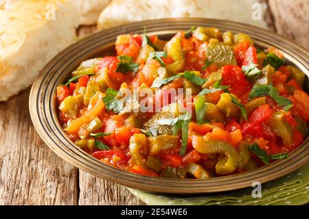 Taktouka est une salade marocaine simple faite de tomates et de poivrons verts rôtis en gros plan dans une assiette sur la table. Horizontale Banque D'Images