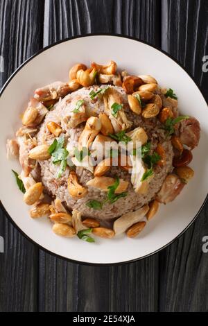 Le bœuf haché et le riz libanais épicés sont servis avec des noix grillées et du poulet juteux râpé dans l'assiette sur la table. Vue verticale du dessus à partir de Banque D'Images