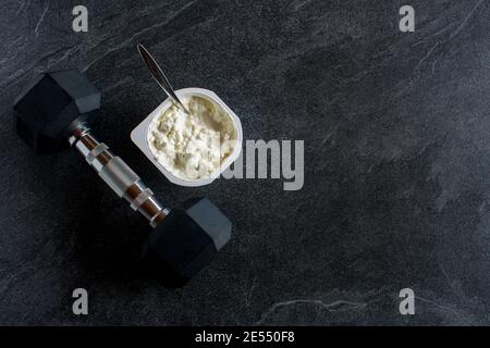 haltère avec des aliments protéinés sur fond de table sombre avec copie espace Banque D'Images