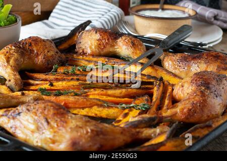 Frites de patate douce avec des cuisses de poulet cuites au four sur un plaque de cuisson Banque D'Images