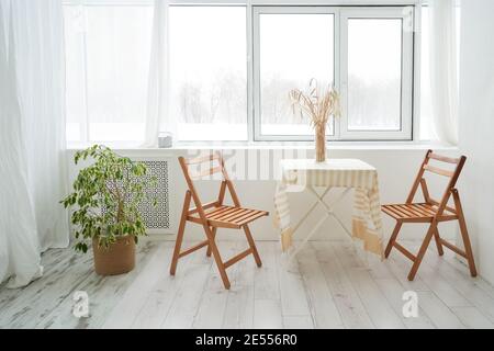 Table et deux chaises. Belle lumière et intérieur en bois. Maison confortable, minimalisme. Table et deux chaises. Banque D'Images