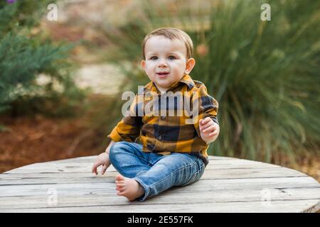 Un bébé garçon de onze mois en plein air en hiver dans un cadre de centre-ville. Banque D'Images