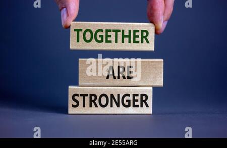 Ensemble, sont des symboles plus forts. Les mots de concept « Together are renforcer » sur des blocs de bois sur un magnifique fond gris. Main d'homme d'affaires. Affaires, motif Banque D'Images
