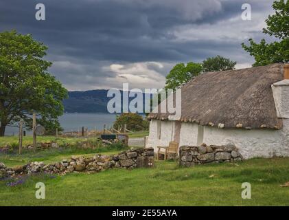 Île de Skye en bord de lac en pierre, chaumière de chaume d'un étage Banque D'Images